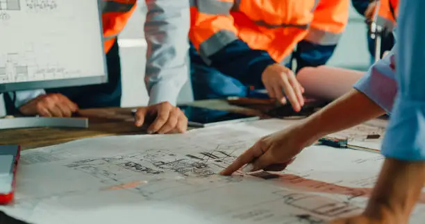 people checking plans on a table and pointing to it